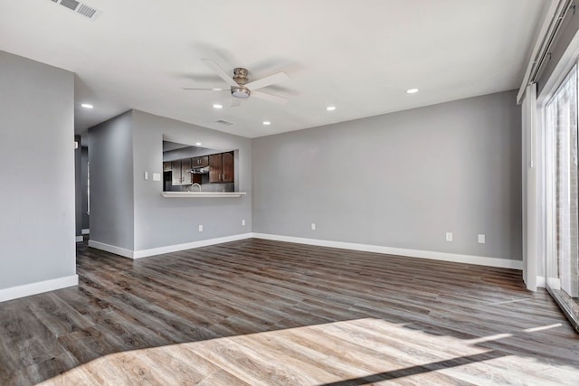 unfurnished living room featuring dark hardwood / wood-style floors and ceiling fan