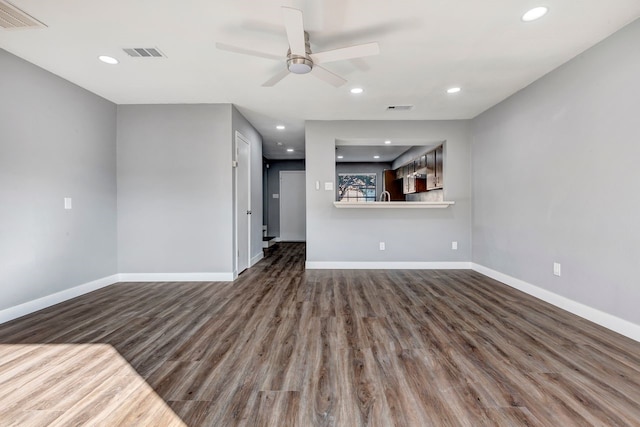 unfurnished living room with ceiling fan and dark wood-type flooring