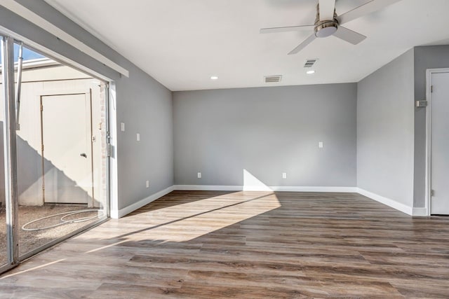 spare room with ceiling fan and dark wood-type flooring