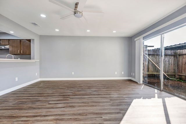 unfurnished living room featuring ceiling fan and dark hardwood / wood-style flooring