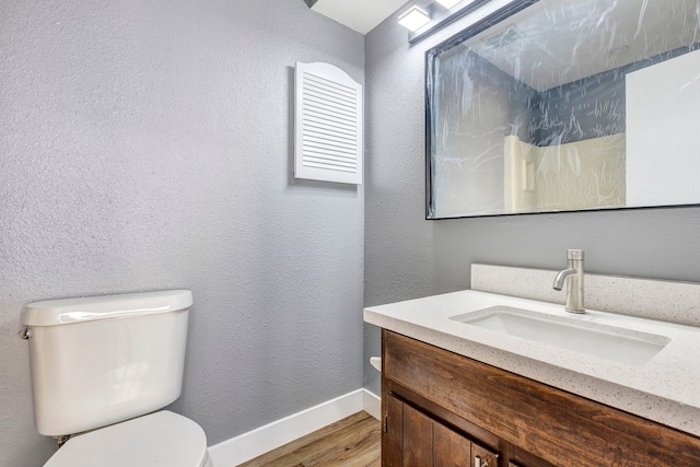 bathroom with vanity, toilet, and wood-type flooring