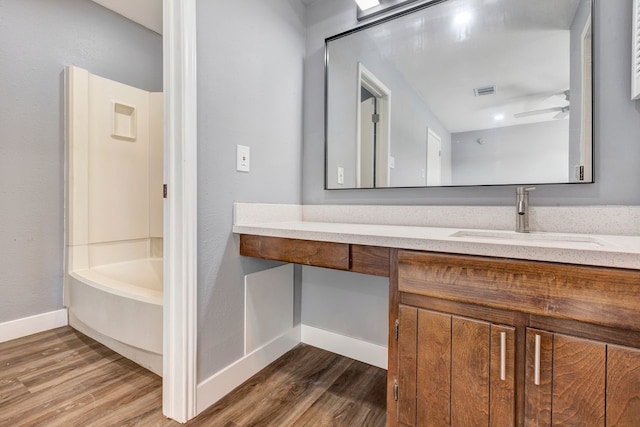 bathroom featuring vanity, ceiling fan, washtub / shower combination, and wood-type flooring