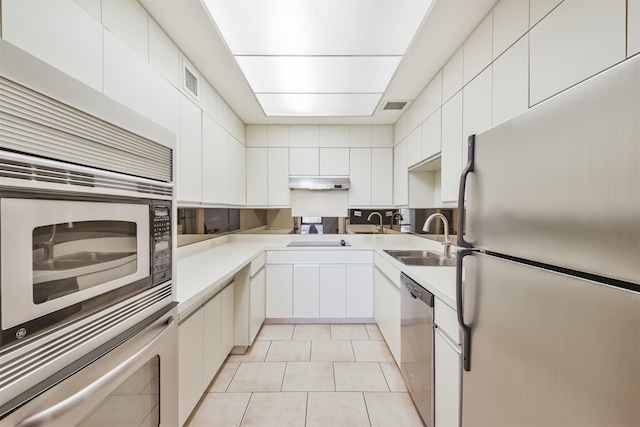 kitchen with sink, white cabinetry, stainless steel appliances, and light tile patterned floors