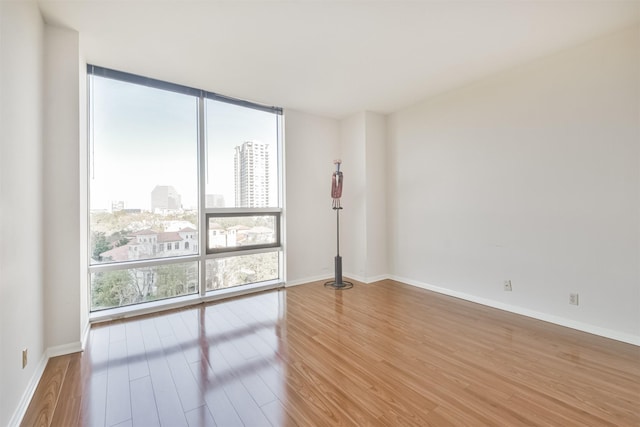 spare room with hardwood / wood-style floors and floor to ceiling windows