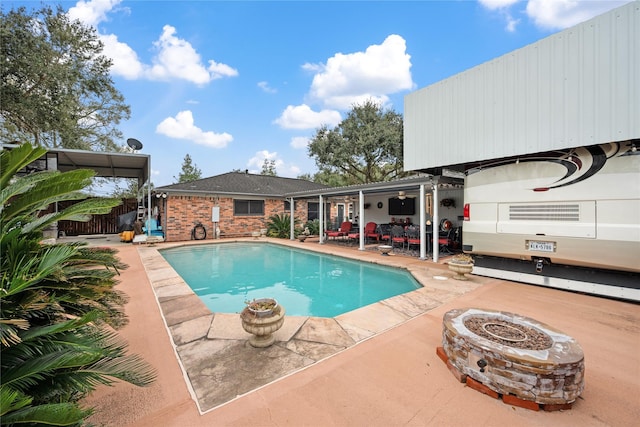 view of swimming pool with an outdoor fire pit and a patio