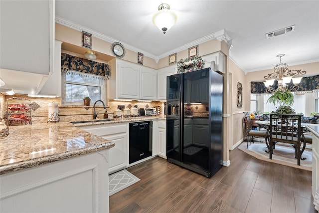 kitchen with black appliances, hanging light fixtures, a notable chandelier, sink, and white cabinetry