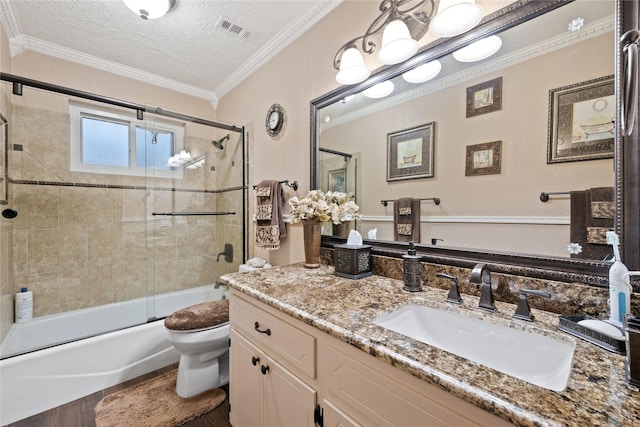 full bathroom featuring a textured ceiling, ornamental molding, toilet, bath / shower combo with glass door, and vanity