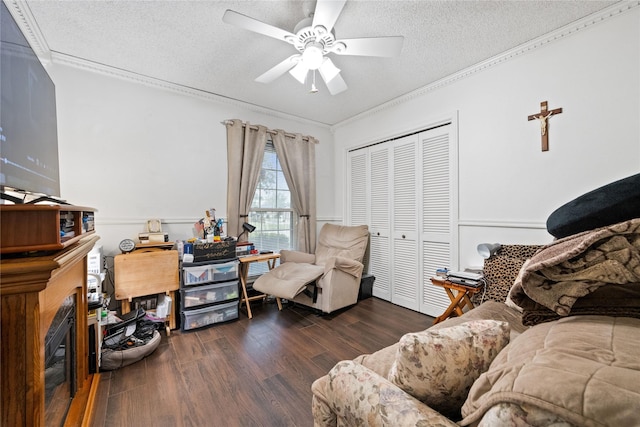 home office with dark wood-type flooring, a textured ceiling, ceiling fan, and ornamental molding