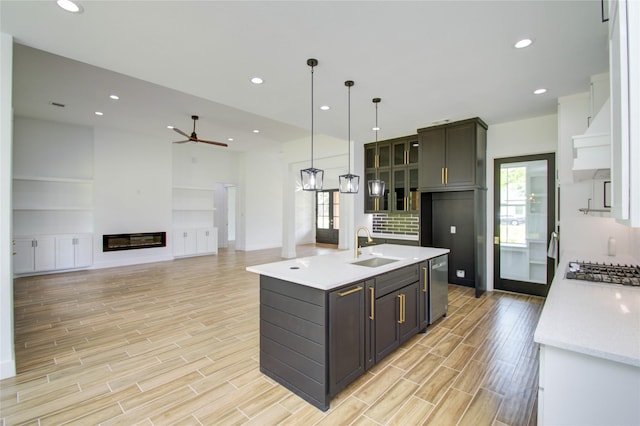 kitchen featuring pendant lighting, light wood-type flooring, ceiling fan, and sink