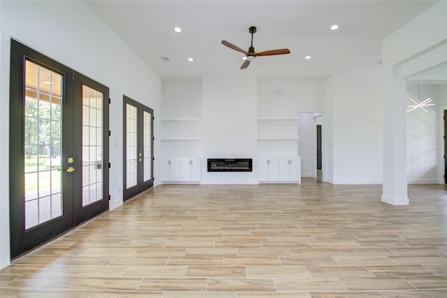 unfurnished living room featuring ceiling fan, french doors, and light wood-type flooring