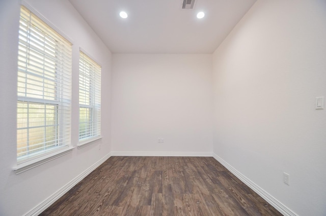 spare room with a healthy amount of sunlight and dark hardwood / wood-style floors