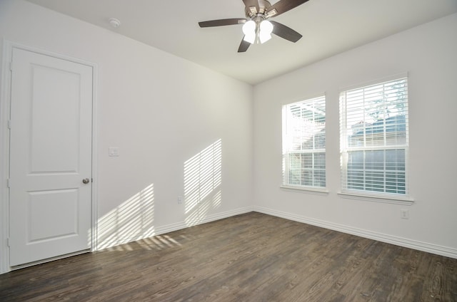 spare room with dark hardwood / wood-style flooring and ceiling fan