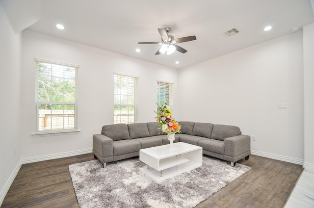 living room featuring ceiling fan and dark wood-type flooring