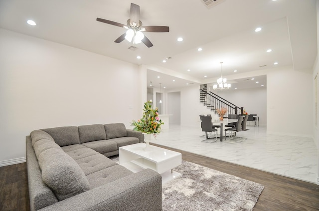 living room featuring ceiling fan with notable chandelier and wood-type flooring