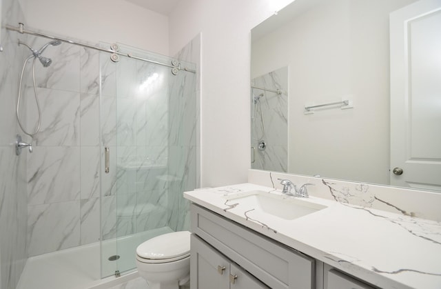 bathroom with walk in shower, vanity, and toilet