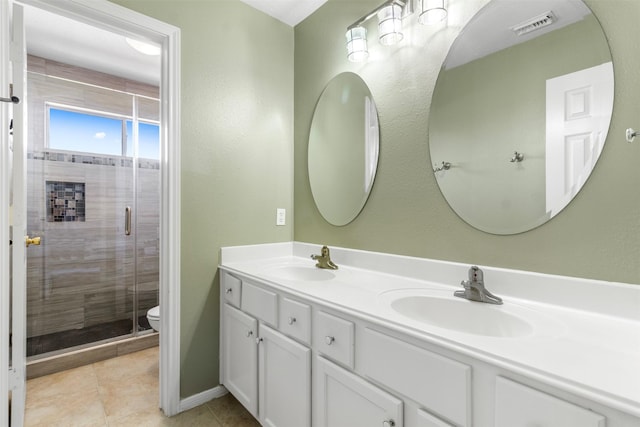 bathroom featuring tile patterned floors, vanity, toilet, and walk in shower