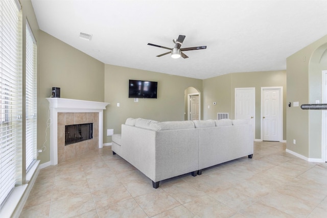 living room featuring ceiling fan, light tile patterned flooring, and a fireplace