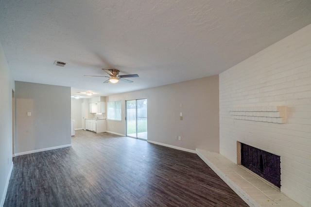 unfurnished living room featuring a fireplace, a textured ceiling, hardwood / wood-style flooring, and ceiling fan