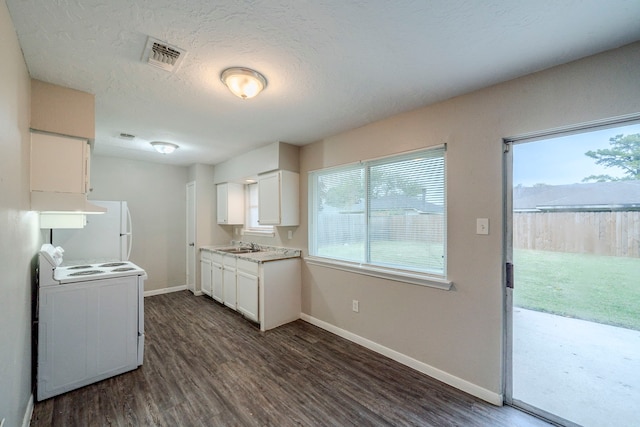 kitchen featuring dark hardwood / wood-style flooring, a textured ceiling, white refrigerator, white cabinets, and range