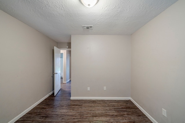 spare room featuring dark hardwood / wood-style floors and a textured ceiling