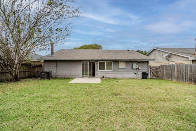 rear view of house with a lawn, cooling unit, and a patio area