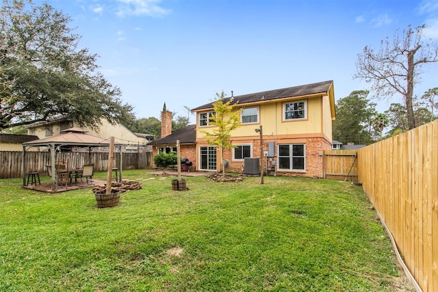 back of property with a gazebo, cooling unit, and a lawn