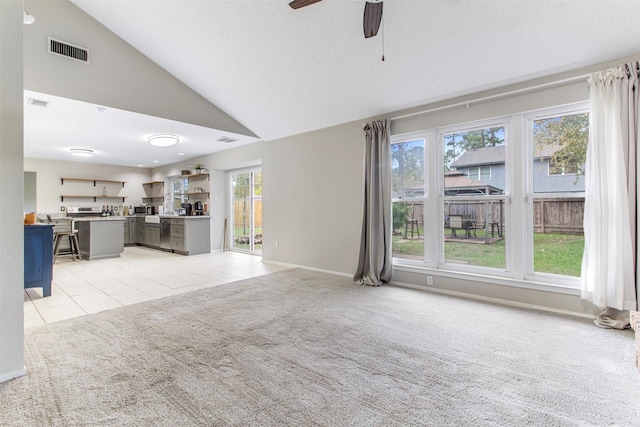 unfurnished living room featuring a textured ceiling, ceiling fan, light carpet, and high vaulted ceiling