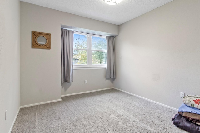 carpeted empty room with a textured ceiling