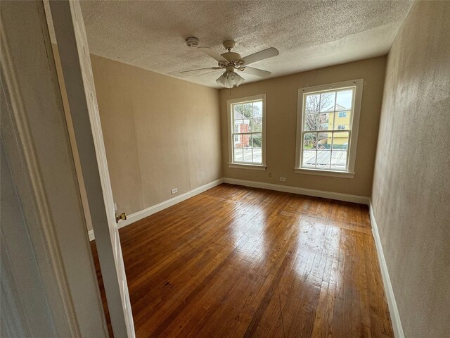 spare room with ceiling fan, a textured ceiling, and hardwood / wood-style flooring