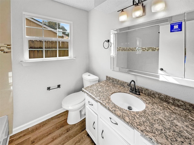 bathroom featuring walk in shower, hardwood / wood-style floors, a textured ceiling, toilet, and vanity