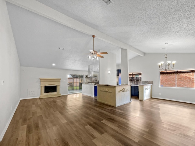 unfurnished living room with vaulted ceiling with beams, dark hardwood / wood-style floors, ceiling fan with notable chandelier, and a wealth of natural light