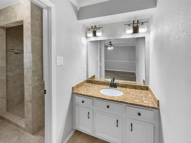 bathroom featuring a tile shower, ceiling fan, tile patterned flooring, and vanity