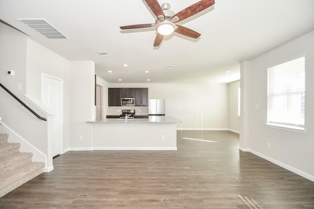 unfurnished living room with dark hardwood / wood-style flooring and ceiling fan