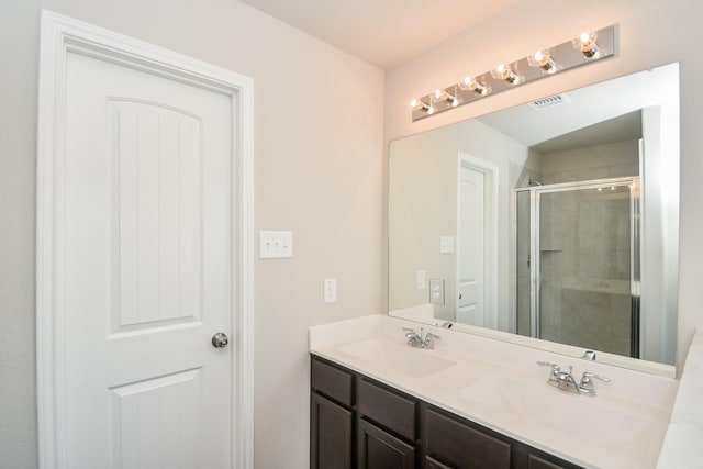 bathroom featuring vanity and a shower with shower door