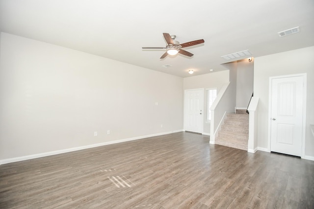 unfurnished living room featuring ceiling fan and dark hardwood / wood-style flooring