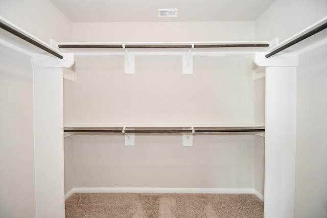 walk in closet featuring light carpet