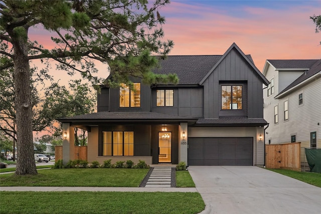 modern inspired farmhouse with a yard, covered porch, and a garage