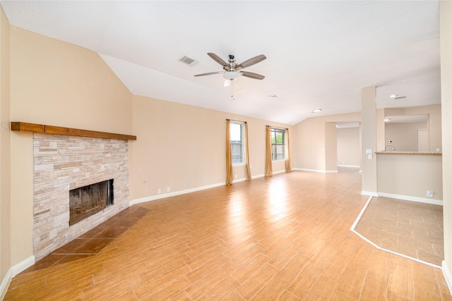 unfurnished living room featuring ceiling fan, a fireplace, vaulted ceiling, and light wood-type flooring