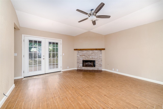 unfurnished living room featuring a fireplace, french doors, light hardwood / wood-style flooring, and ceiling fan