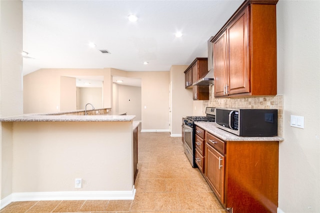 kitchen featuring light stone countertops, sink, wall chimney range hood, backsplash, and appliances with stainless steel finishes