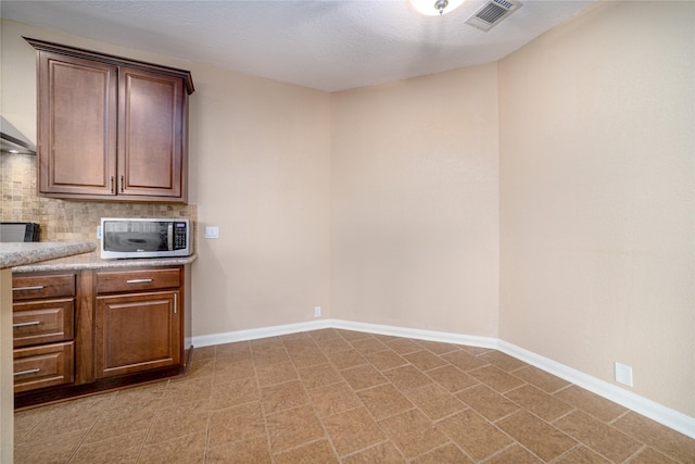 kitchen with a textured ceiling and tasteful backsplash