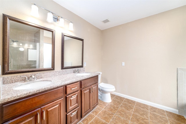 bathroom featuring tile patterned flooring, vanity, toilet, and a shower with door