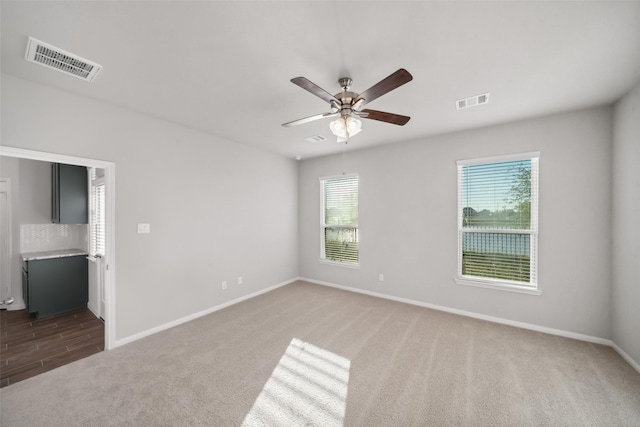 carpeted empty room featuring ceiling fan