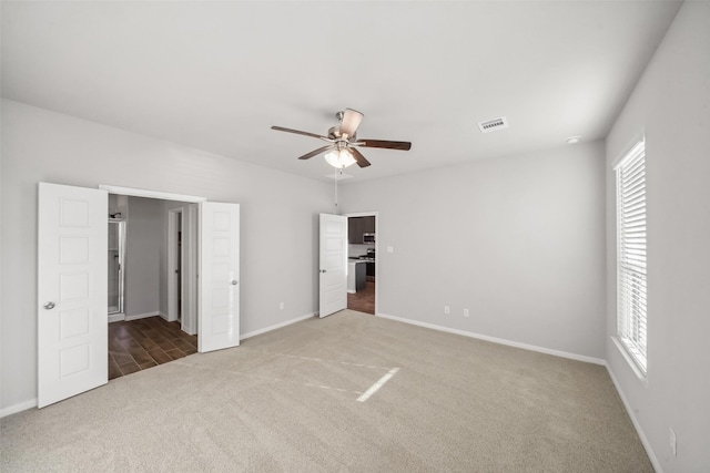 unfurnished bedroom featuring ceiling fan, carpet floors, and multiple windows