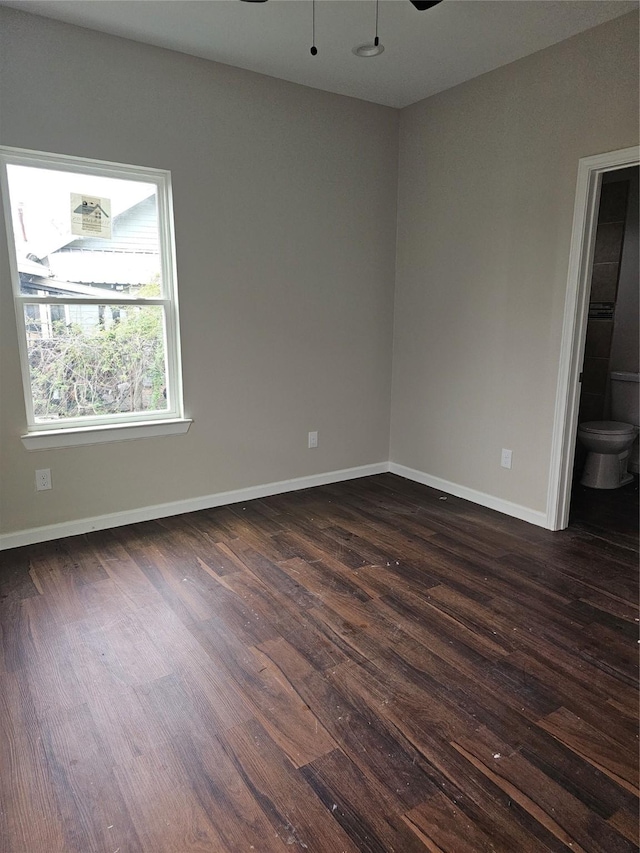 spare room featuring ceiling fan and dark wood-type flooring