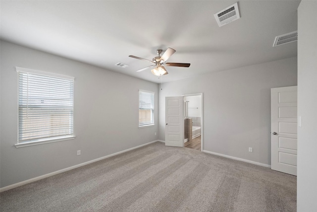 unfurnished bedroom with ensuite bath, ceiling fan, and light carpet