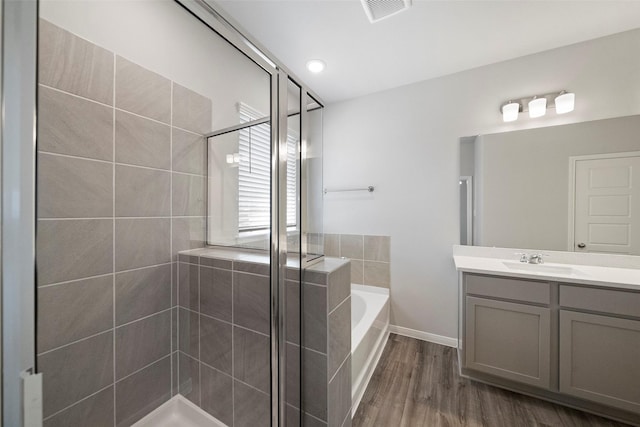 bathroom featuring hardwood / wood-style floors, vanity, and separate shower and tub