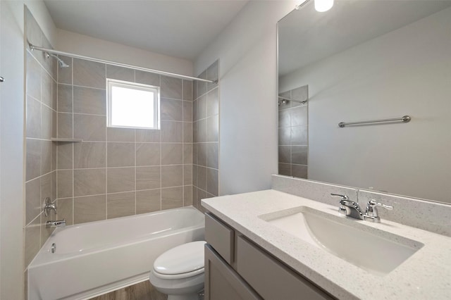 full bathroom with vanity, tiled shower / bath combo, hardwood / wood-style flooring, and toilet