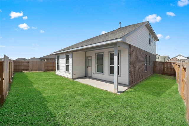 back of property with a yard and a patio