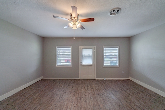 unfurnished room featuring a textured ceiling, dark hardwood / wood-style flooring, and ceiling fan